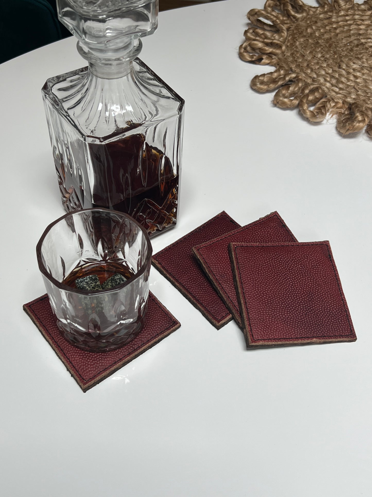 4 set of coasters with a Decanter of bourbon and glass of bourbon with whiskey stones.